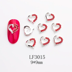 Macro view of LF3015 hollow heart nail art charm with red crystal and silver alloy base