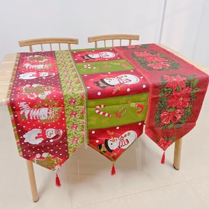 Detail of Christmas table runners with snowman patterns and decorative red tassels
