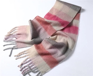 Détail d'une écharpe d'hiver douce à carreaux rose et gris avec des textures de franges