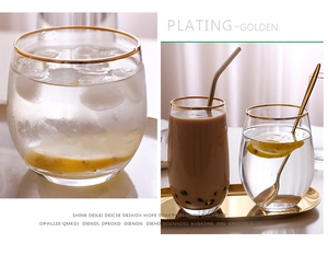 Detail of gold-rimmed egg-shaped glasses showing the electroplated rim and clear glass texture