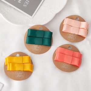 Detail of four pairs of ribbed ribbon bow hair clips in vibrant candy colors on cards