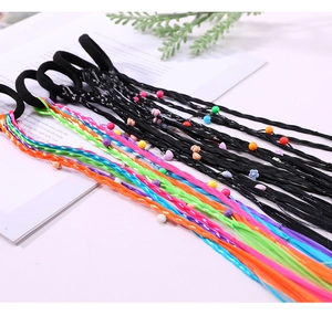 Detailed view of colorful braided hair extensions with beads and flower charms