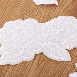 White rose flower lace embroidery patch for clothing on a warm wooden background