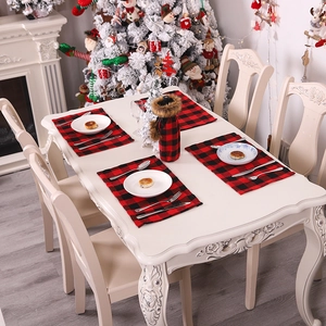 Christmas red and black buffalo plaid placemats and wine bottle covers on a festive table