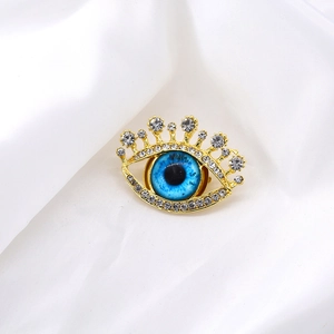 Creative eye-shaped gold brooch with blue crystal and sparkling diamond eyelashes