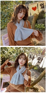Detail of light grey plush scarf featuring a stylish cross-over tuck design for winter