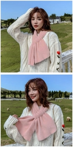 Detail view of pink plush cross scarf worn by models in a natural pasture setting
