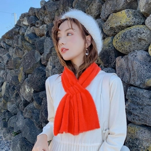 Vibrant orange fuzzy scarf styled with a white beret and knit sweater in outdoor winter