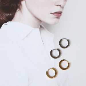 Polished silver and 18K gold plated hoop earrings displayed on a fashion magazine page