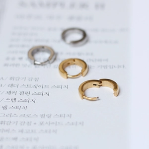 Detail of brushed gold and silver hoop earrings on magazine background