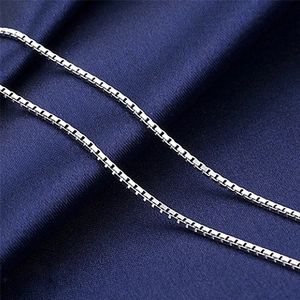 Polished silver box chain necklace with elegant 1mm square links on blue silk fabric