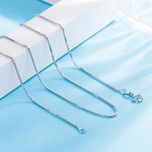Macro shot showing detail of 1mm silver box chain necklace with metallic luster