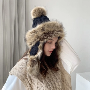 Women's knitted trapper hat with faux fur lining and triple fluffy pom poms