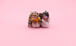 Close-up of cute cartoon sushi cat keychains in orange and black tuxedo styles