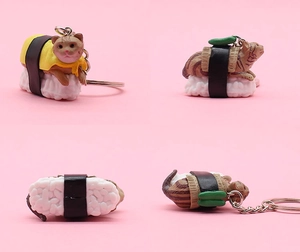 Detail view showing a cute sushi cat keychain with rice base and metal ring on pink background