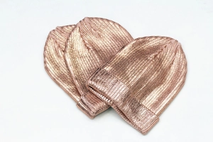 Stack of three metallic rose gold knitted beanies for men and women in hip-hop style