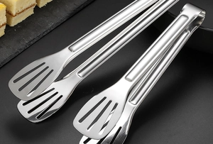 Détail macro de pinces alimentaires en acier inoxydable avec design creux sur fond sombre