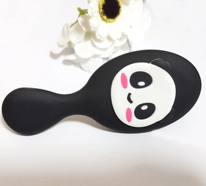 Detail of cute panda cartoon paddle brush with black handle and massage bristles