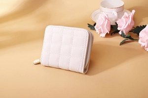 Mini quilted zipper purse in pale pink with gold hardware on a feminine aesthetic desk