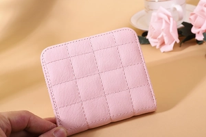 Detail view of pink quilted faux leather mini wallet with refined stitching and rounded corners