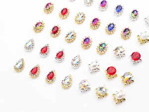 Macro detail of mixed alloy nail art charms with colorful K9 rhinestones and pearls