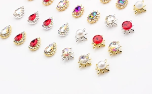Macro shot of assorted colorful K9 crystal nail charms in gold and silver metal settings