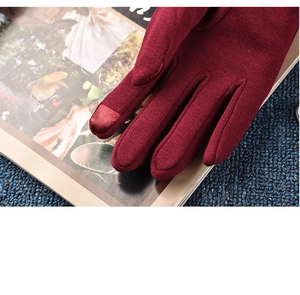 Close-up of wine red knitted gloves showing sensitive touchscreen tips and fine texture