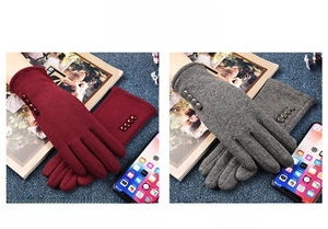 Close-up of red and grey thermal knit gloves with four buttons for winter touchscreen use