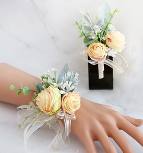 Detail of cream rose corsage and wrist flower with champagne ribbons for weddings