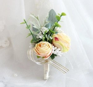 Detail of handmade champagne silk rose boutonniere with eucalyptus leaves and gold-edged ribbon