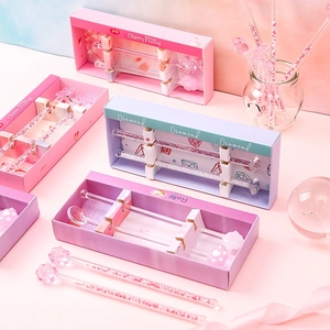 Pink glass stirring rods with cherry blossom, diamond, and cat paw designs in a gift box