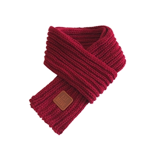 Women's burgundy knit scarf with brown leather tag for a stylish autumn winter look