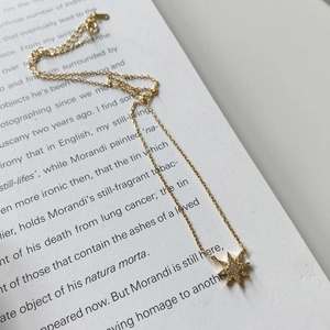 Close-up of a 925 sterling silver gold-plated star pendant on a dainty choker necklace