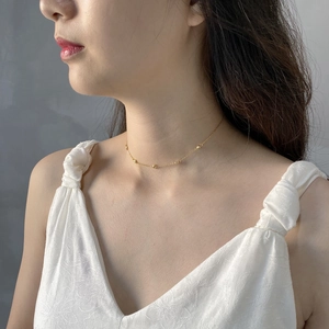 Detail of a 925 sterling silver minimalist galaxy choker necklace with gold bead accents