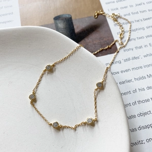 Detail of 925 sterling silver gold choker necklace with five round cubic zirconia stones
