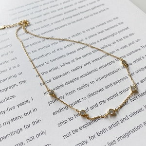 Detail of 925 sterling silver gold choker necklace featuring five clear zircon pendants