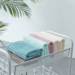 Soft cotton waffle weave towel set in Morandi colors neatly stacked on a cart