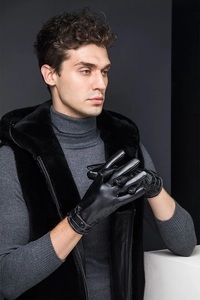 Close-up of black PU leather gloves featuring adjustable wrist strap for secure fit