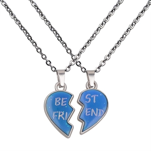 Macro shot of silver-tone split heart necklaces with Best Friend engraving and blue glitter