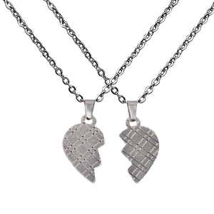 Macro detail of silver stainless steel heart puzzle necklaces with textured grid pattern