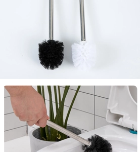 Dettaglio dello scopino per WC in acciaio inox con setole nere che pulisce un bagno moderno