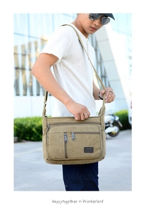Detail view of khaki canvas messenger bag featuring multiple zippers and durable texture