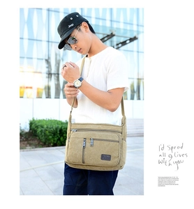 Detail of khaki canvas crossbody bag showing multiple zipper pockets and adjustable strap