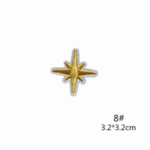 Detail view of a 3.2cm golden eight-point star embroidered patch with fine textures