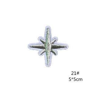 Detailed embroidery of a silver star patch with light blue borders on a white background