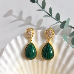 Vintage gold teardrop earrings with malachite stones and pavé zircon accents on a shell