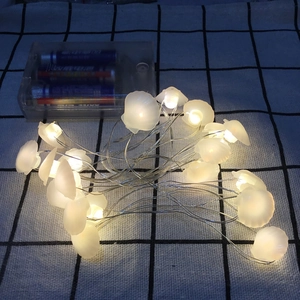 Close-up of shell-shaped LED string lights with a transparent battery power box