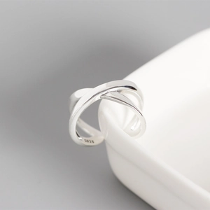 Macro detail of S925 sterling silver hallmark on minimalist crossover open ring