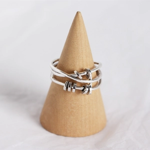 Detail of S925 sterling silver multi-layer crossover ring with movable round charm accents