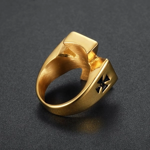 Brushed gold stainless steel men's ring with embossed cross design on a textured surface